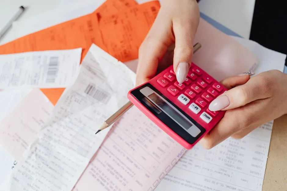 Hands reviewing bills and a calculator at home