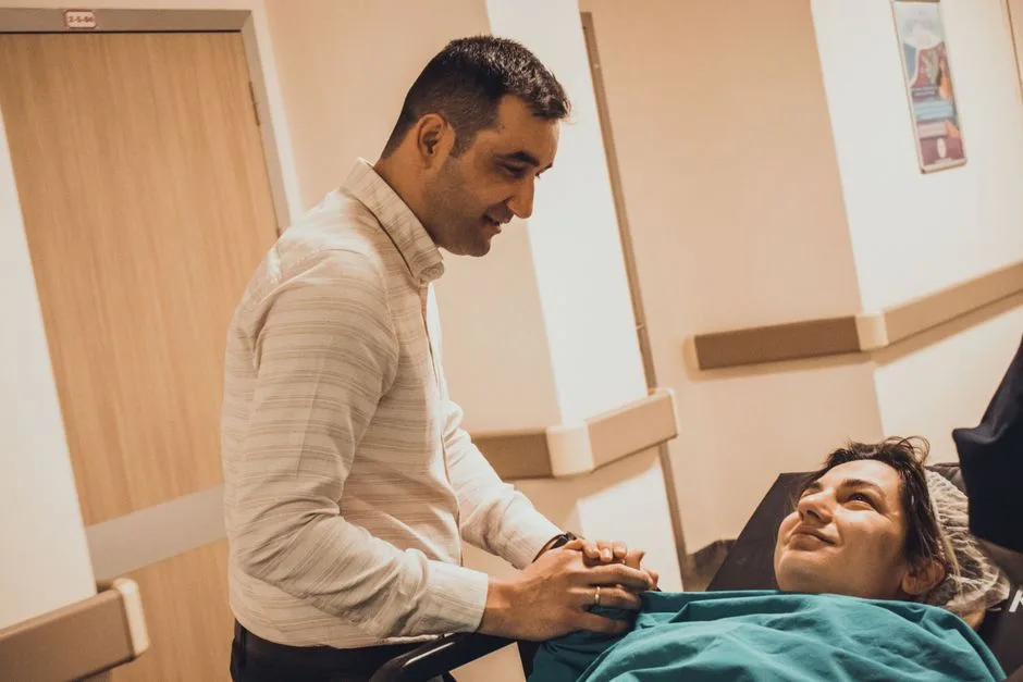Companion holding a patient's hand in a hospital corridor