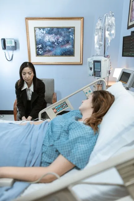 Visitor sitting at a patient's hospital bedside