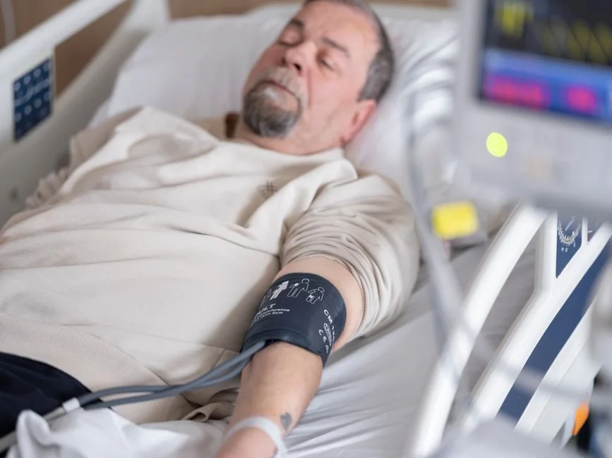 Patient in a hospital bed connected to monitoring equipment