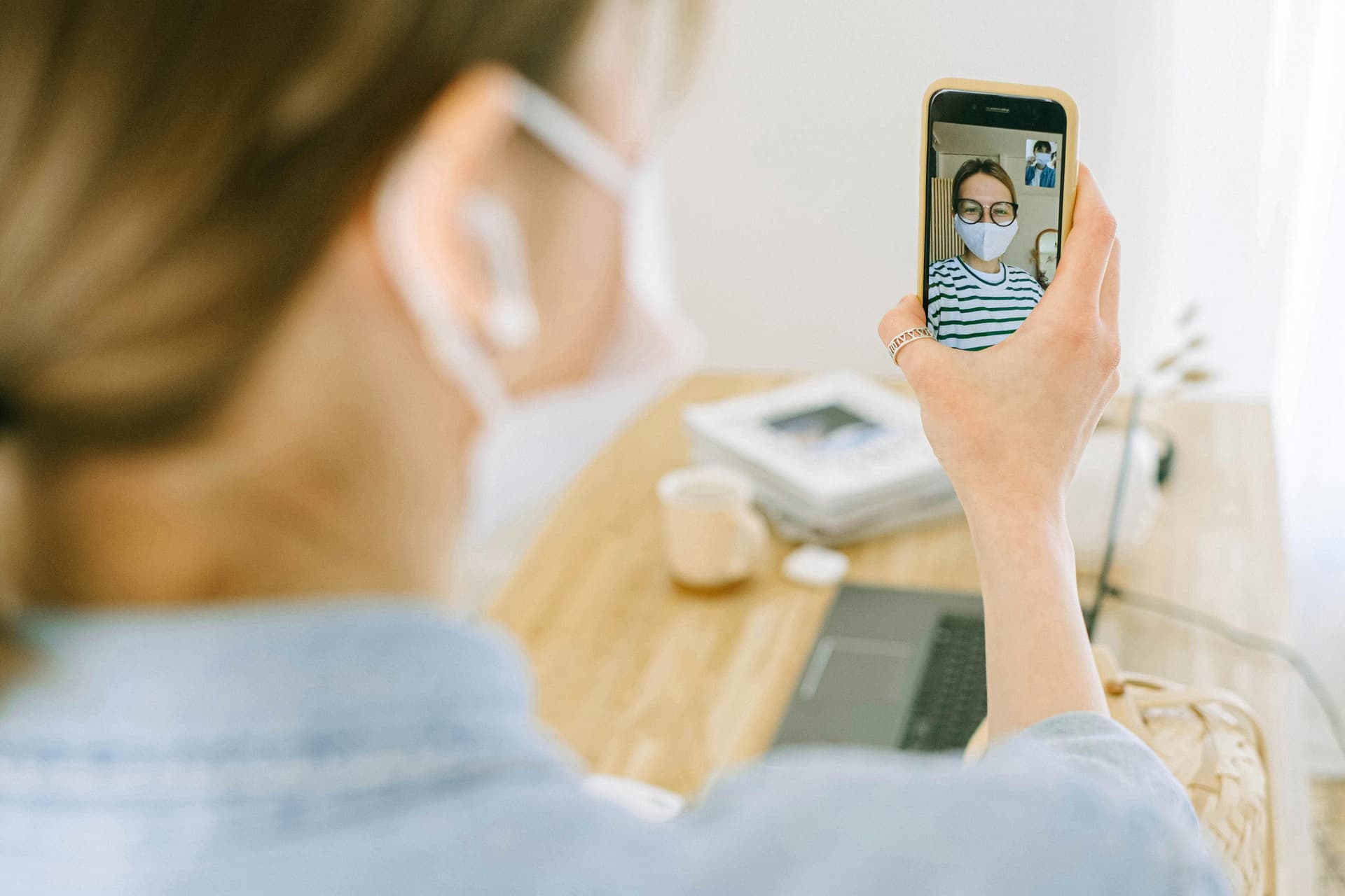 Adult child on phone managing elderly parent's health from a distance