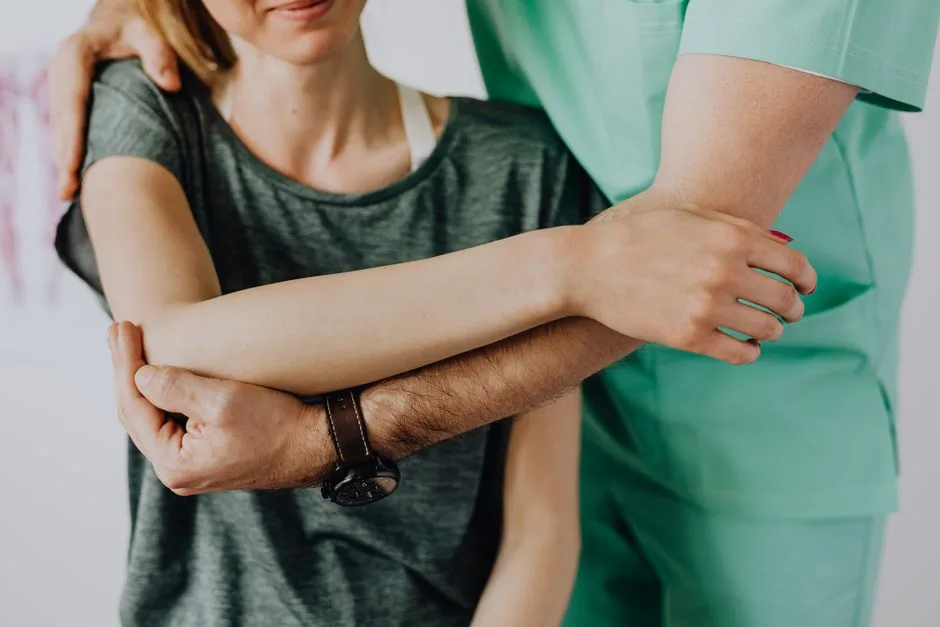 Physiotherapist supporting a patient's arm during mobility exercise