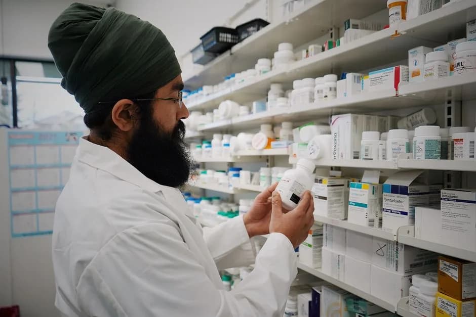 Pharmacist checking a medicine bottle on the shelf