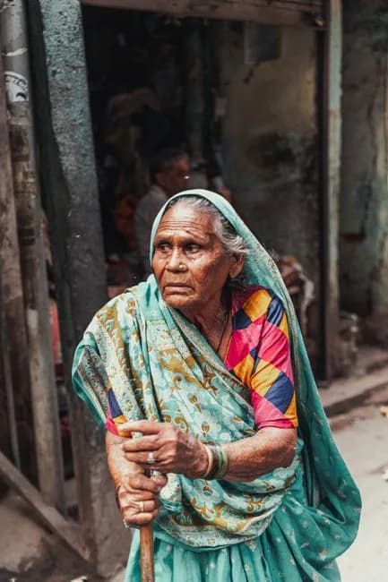 Elderly Indian woman holding a cane for support