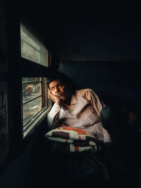 Elderly Indian man reflecting quietly by a window